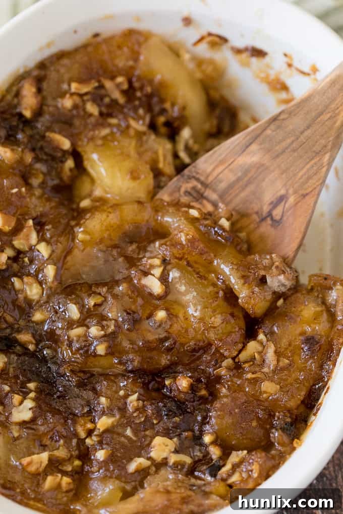 A golden-brown Apple Pie French Toast Casserole in a baking dish with a wooden spoon, ready to be served.