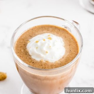A mug of Slow Cooker Peanut Butter Hot Chocolate, topped with whipped cream and a mini peanut butter cup.