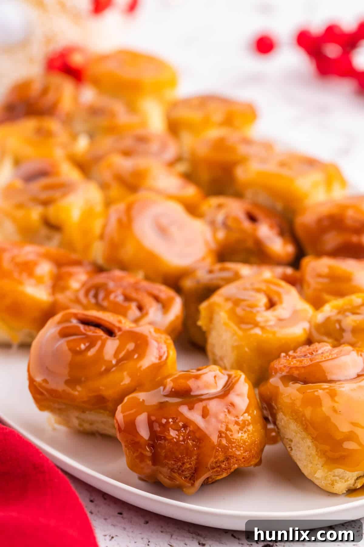 Rum-Kissed Mini Cinnamon Swirls 4 Mini Rum Butter Cinnamon Rolls arranged beautifully on a rustic wooden serving platter, ready for a gathering.
