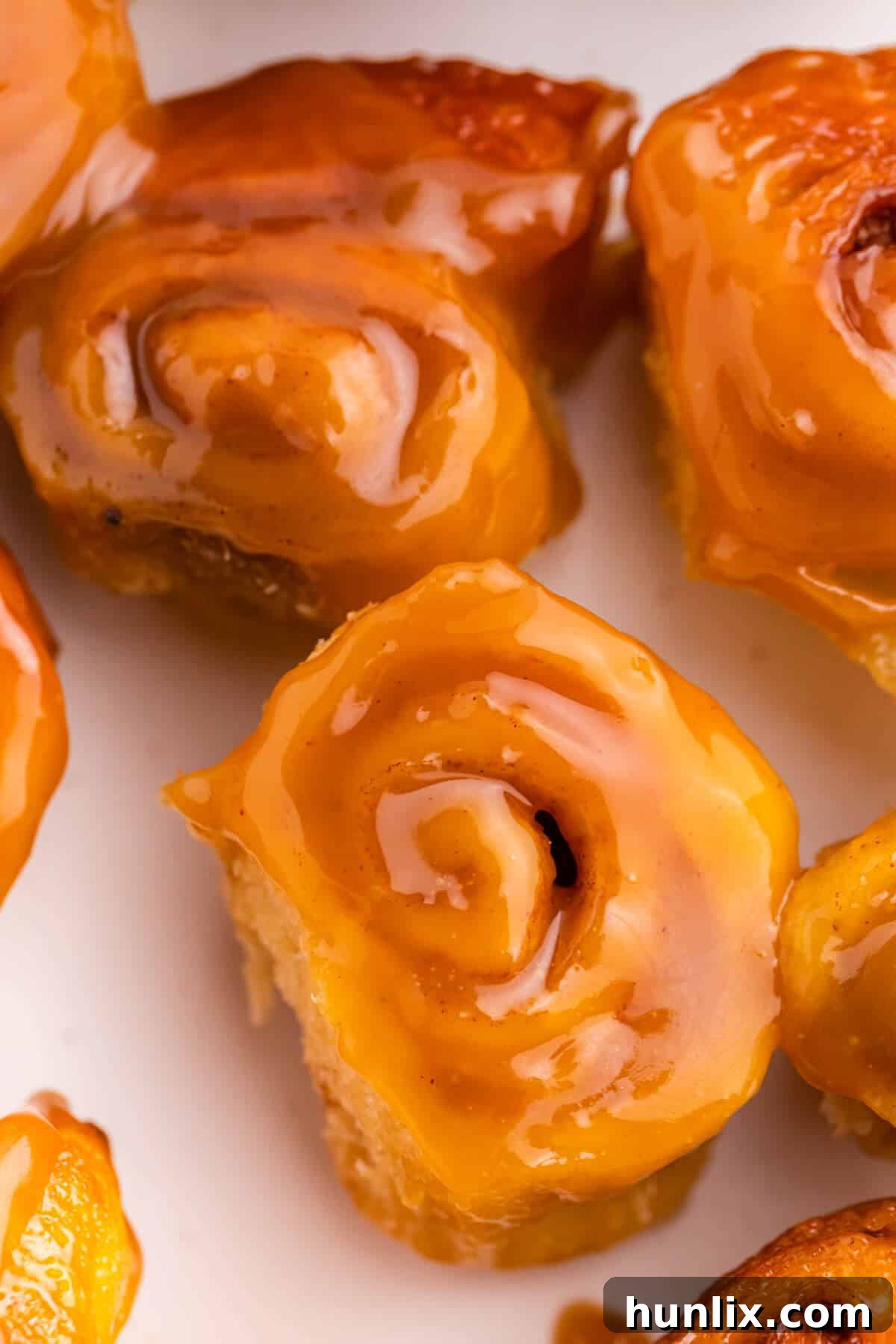 Rum-Kissed Mini Cinnamon Swirls 5 A beautifully arranged serving of Mini Rum Butter Cinnamon Rolls on a white plate, garnished and ready to be enjoyed.
