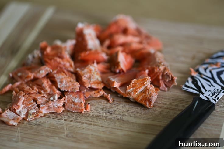 Roughly chopped cooked salmon, ready to be added to the salad.