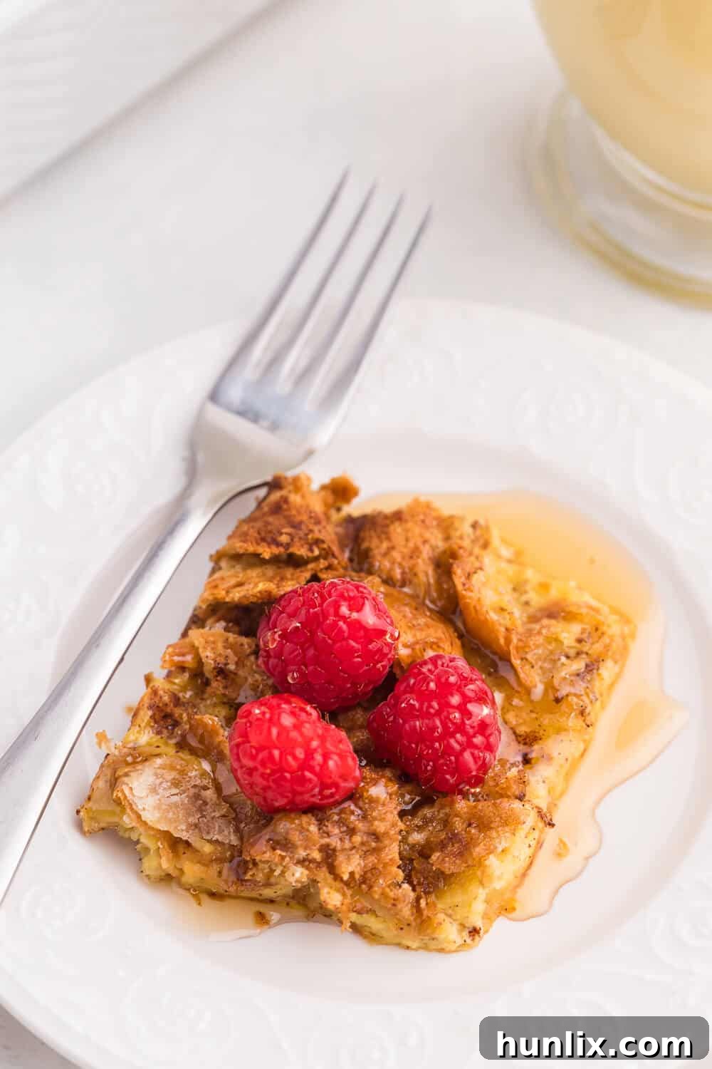 A beautifully presented slice of eggnog breakfast casserole on a white plate, ready to be enjoyed.