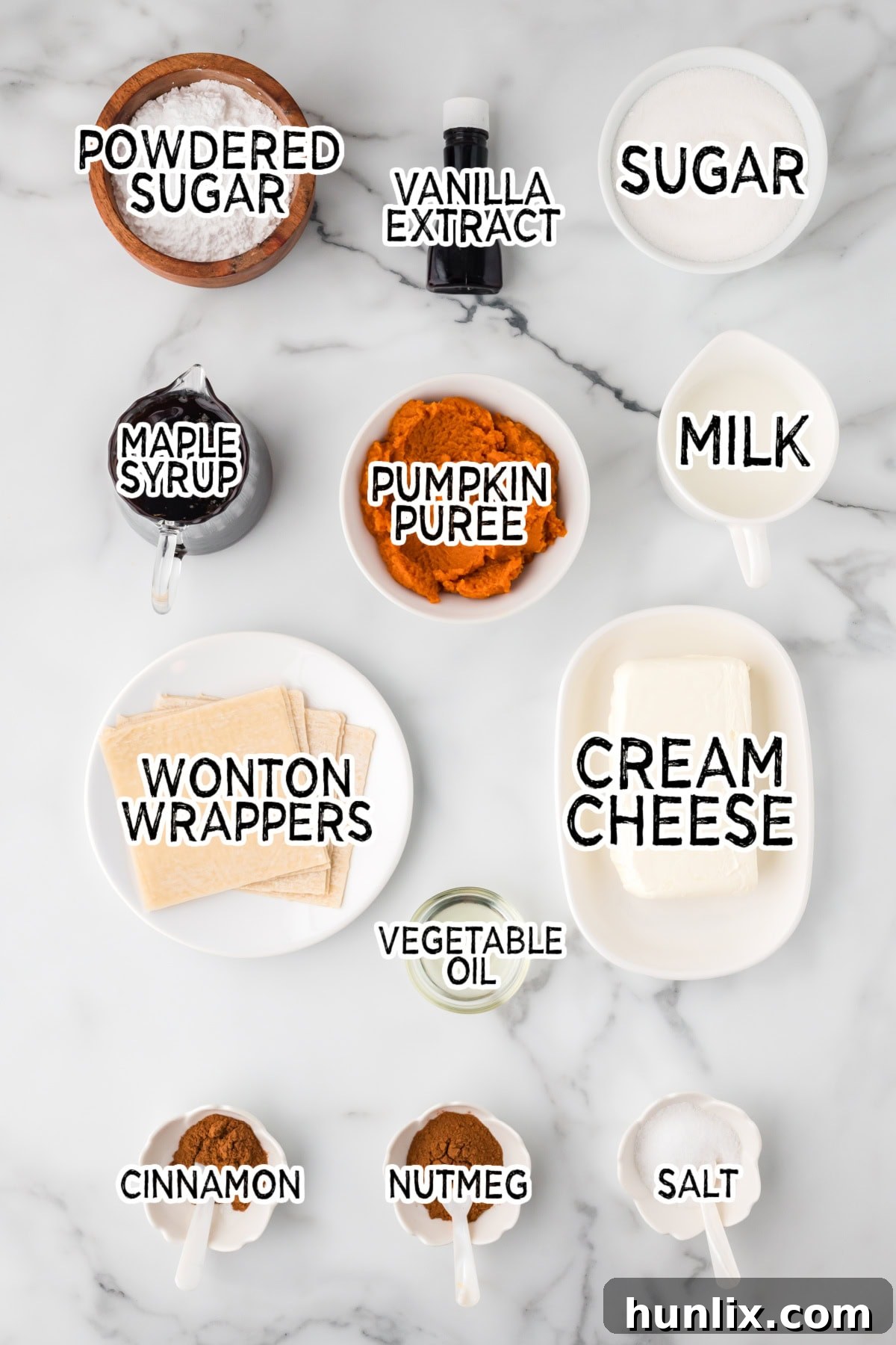Maple-Kissed Pumpkin Cream Cheese Parcels 3 Various ingredients laid out on a clean white kitchen counter, including wonton wrappers, a can of pumpkin puree, cream cheese, spices, and bottles of vanilla and maple syrup.
