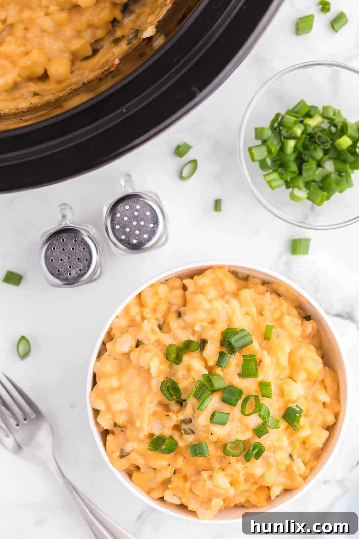 Slow Cooker Cheesy Potatoes - The creamiest potato recipe! Grab your Crockpot for this 4-ingredient side dish with frozen hash browns, cheese soup, and evaporated milk.
