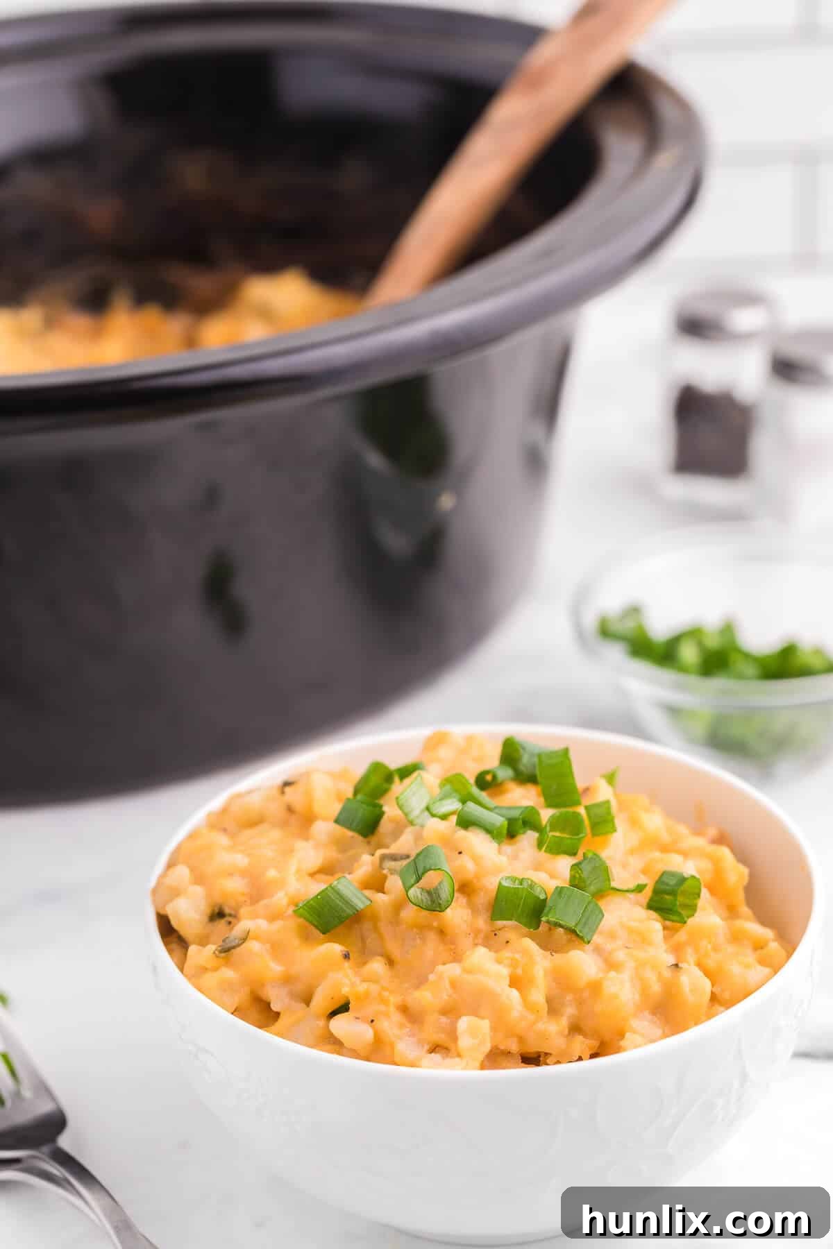 Slow Cooker Cheesy Potatoes - The creamiest potato recipe! Grab your Crockpot for this 4-ingredient side dish with frozen hash browns, cheese soup, and evaporated milk.