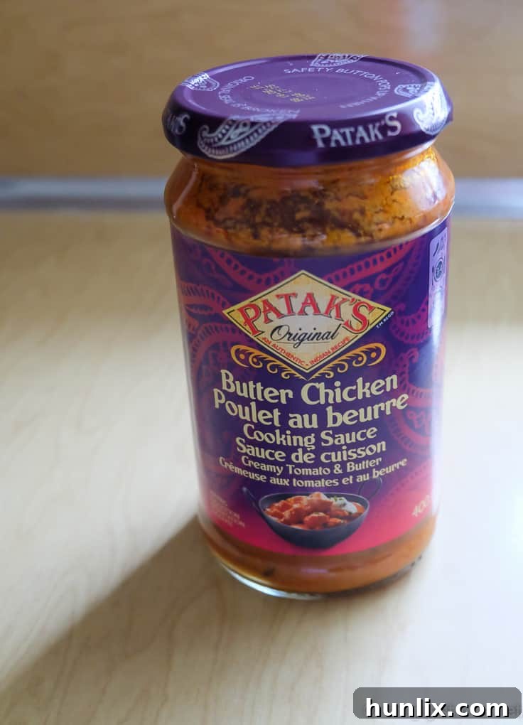 A bowl of rich and creamy Butter Chicken Lasagna Soup, garnished with fresh herbs and cheese, ready to be served.