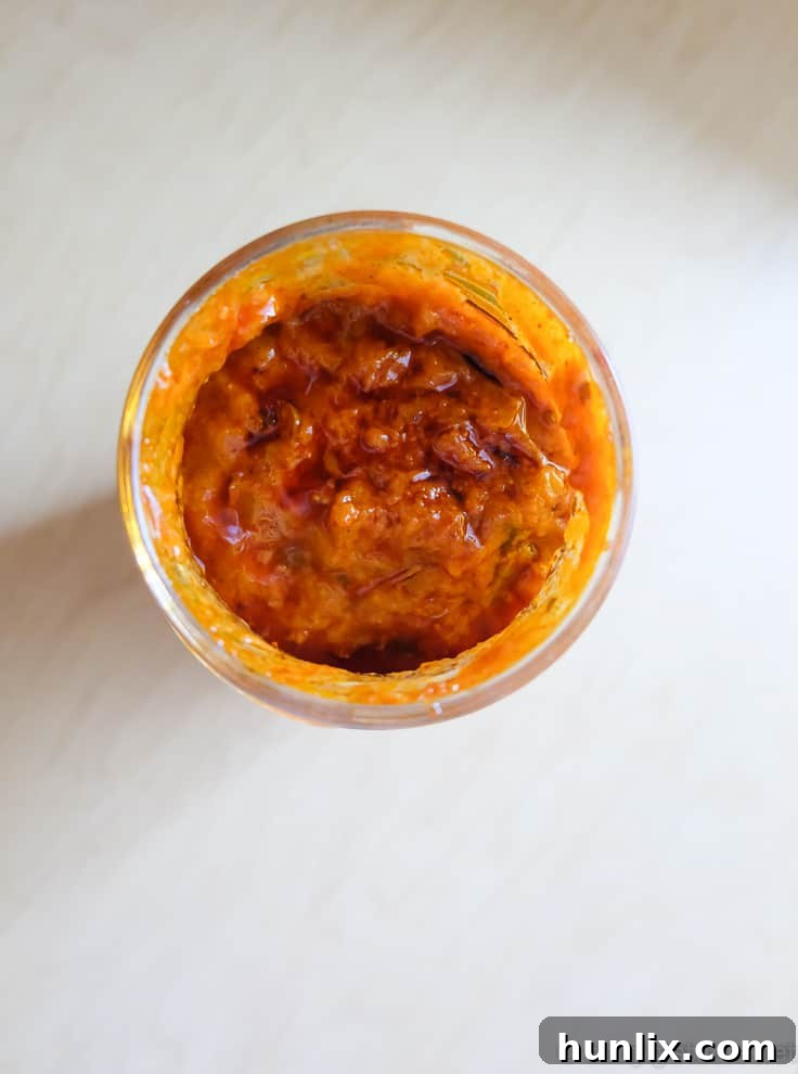 A rustic cutting board with fresh basil and a jar of Patak's Butter Chicken Cooking Sauce, hinting at the culinary adventure ahead.