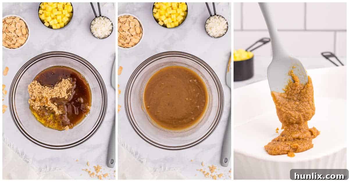 Pineapple Paradise Sticky Buns with Coconut Caramel Sauce 4 A baking dish with the coconut caramel mixture at the bottom, topped with a layer of chopped pineapple, sliced almonds, and coconut flakes, representing the initial steps of making pineapple sticky buns.