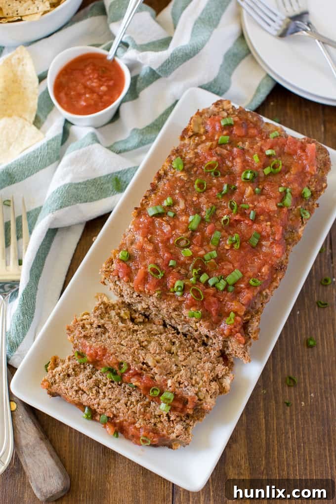 A perfectly baked Mexican Meatloaf, beautifully sliced and presented on a rustic platter, garnished with fresh cilantro.