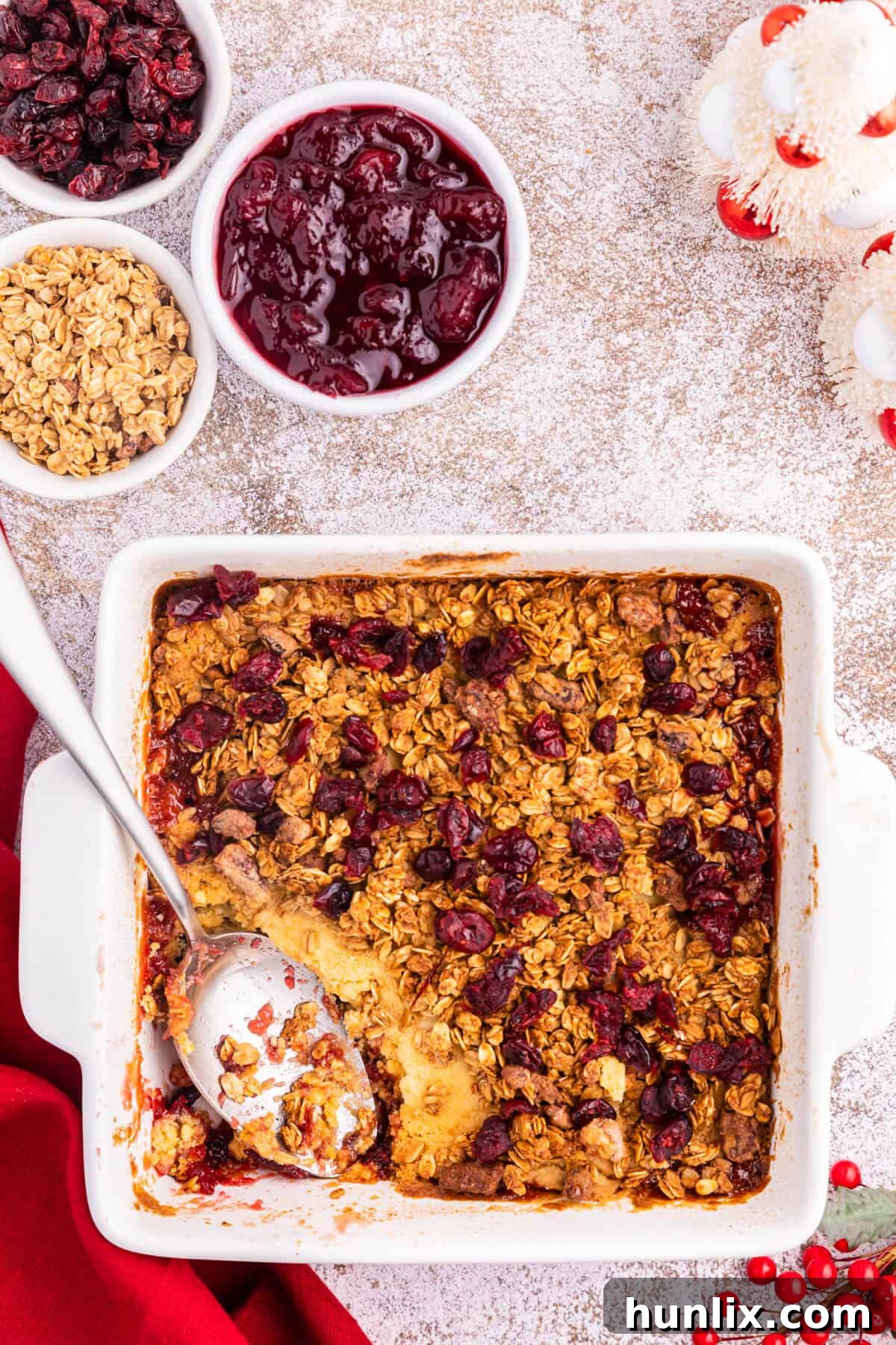 Cranberry Cobbler Dump Cake in a baking pan with a serving spoon.