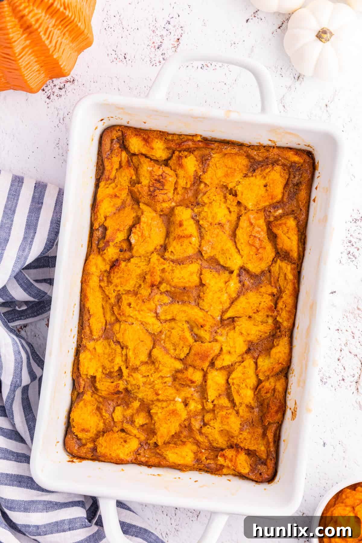 Pumpkin gingerbread pudding in a white pan.