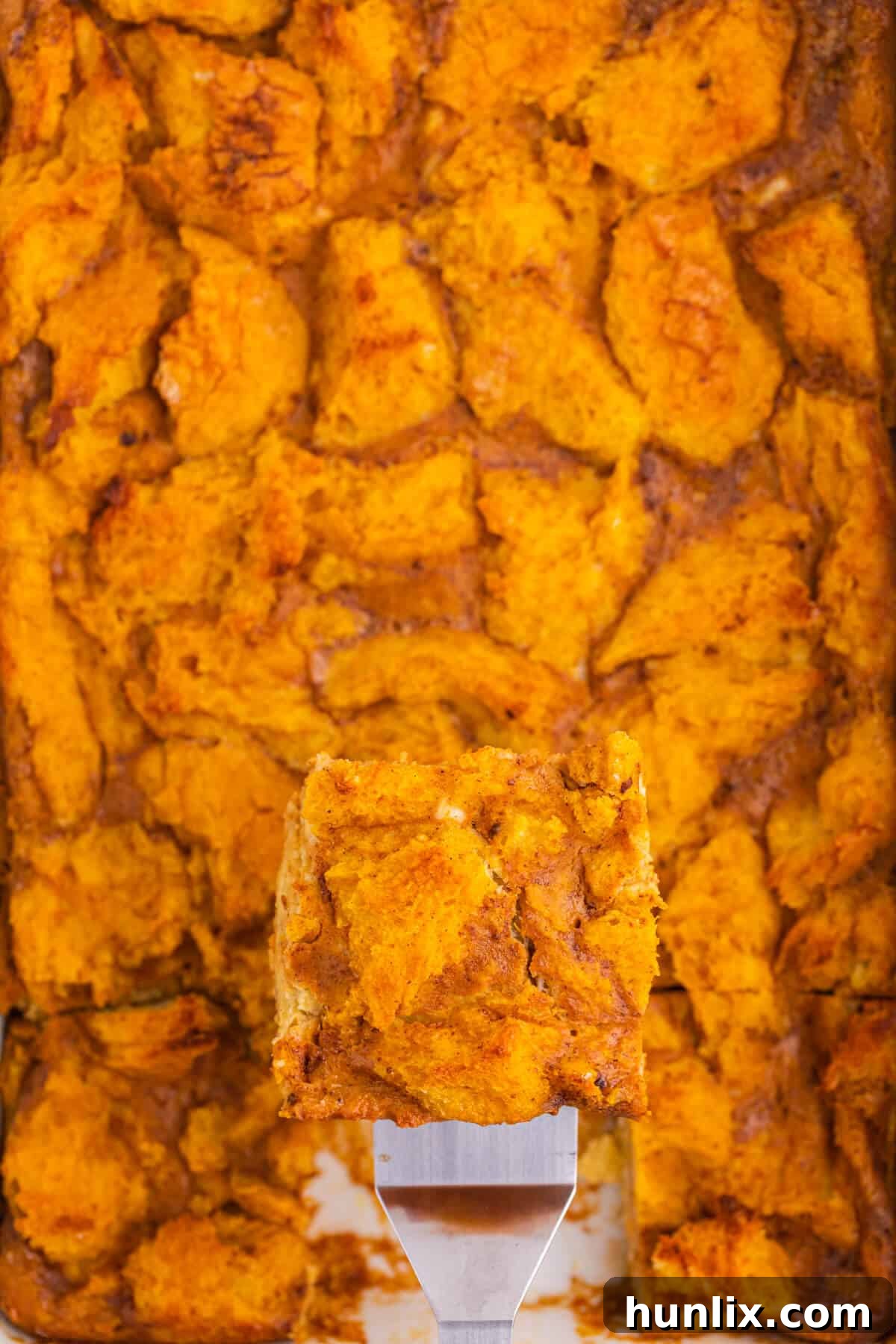 A spatula lifting a piece of pumpkin gingerbread puddning.