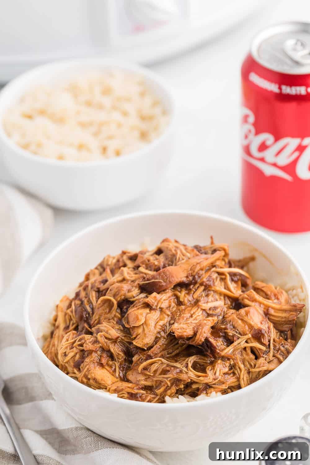 Closeup of ingredients for Cherry Coke Chicken, including boneless chicken breasts, Coca-Cola, BBQ sauce, and canned cherries.