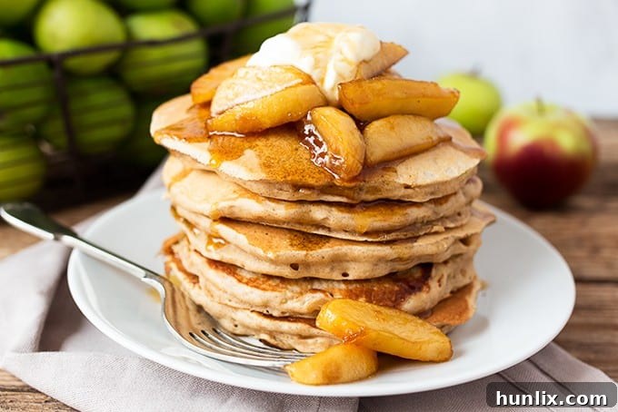 Fluffy Apple Pie Pancakes, topped with syrup-poached apples and crème fraîche, a perfect fall breakfast.