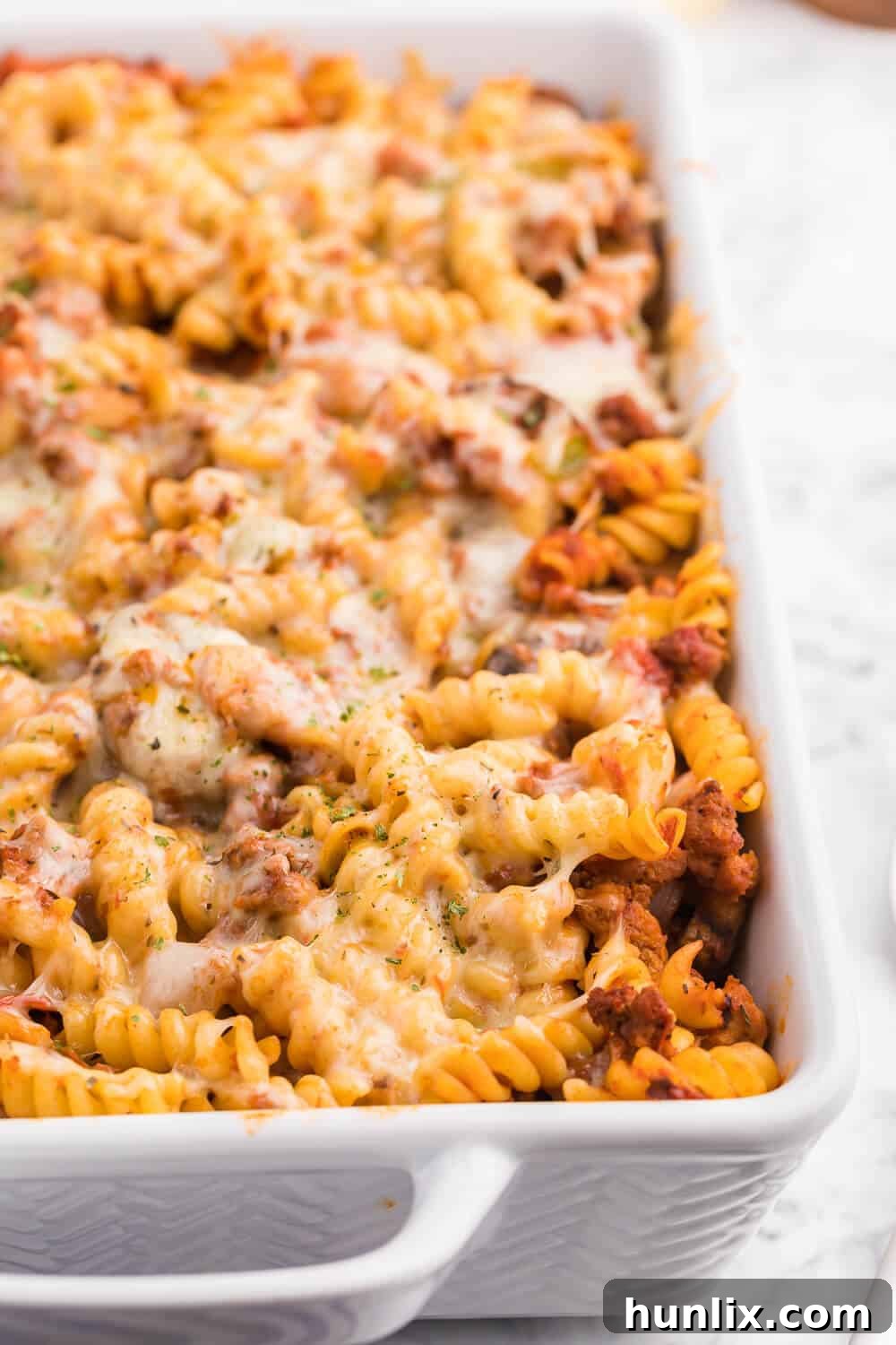 Meatzza Casserole - This crowd pleasing casserole recipe is packed with four kinds of meat, pizza sauce, veggies and oohey gooey cheese!