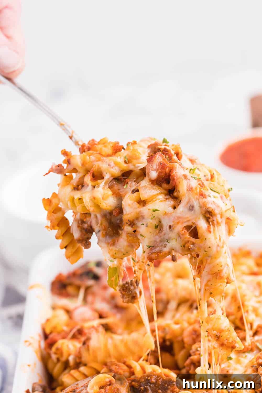 Meatzza Casserole - This crowd pleasing casserole recipe is packed with four kinds of meat, pizza sauce, veggies and oohey gooey cheese!