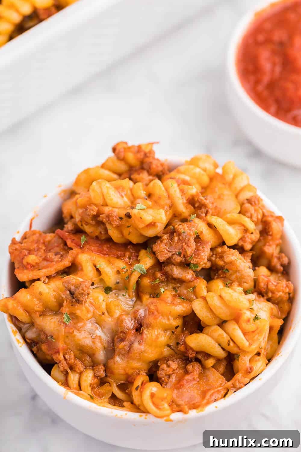 Meatzza Casserole - This crowd pleasing casserole recipe is packed with four kinds of meat, pizza sauce, veggies and oohey gooey cheese!