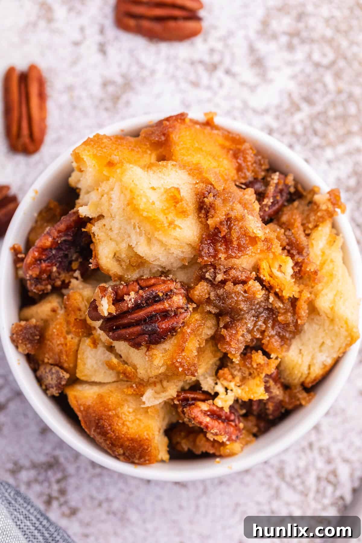 Pecan butter tart buns glistening with a sticky glaze, ready for a bite.