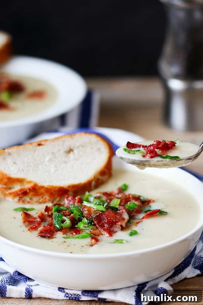 Creamy Cauliflower Bacon Bisque 6 A visually stunning close-up of cauliflower soup with bacon, perfectly garnished on a spoon, ready for a delicious bite.