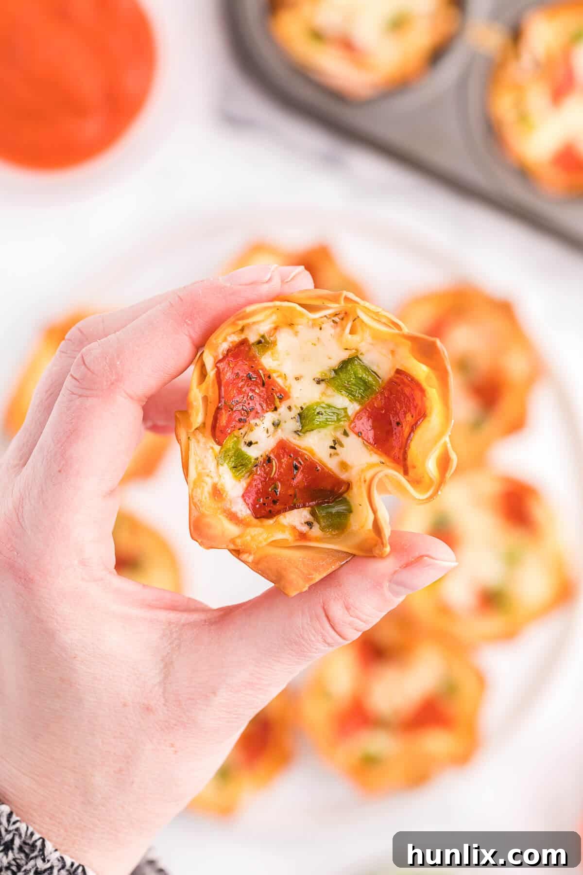 Pizza Wonton Cups Recipe - East meets West in this simple crunchy appetizer. A crispy wonton is filled with cheesy pizza goodness with any toppings you want!