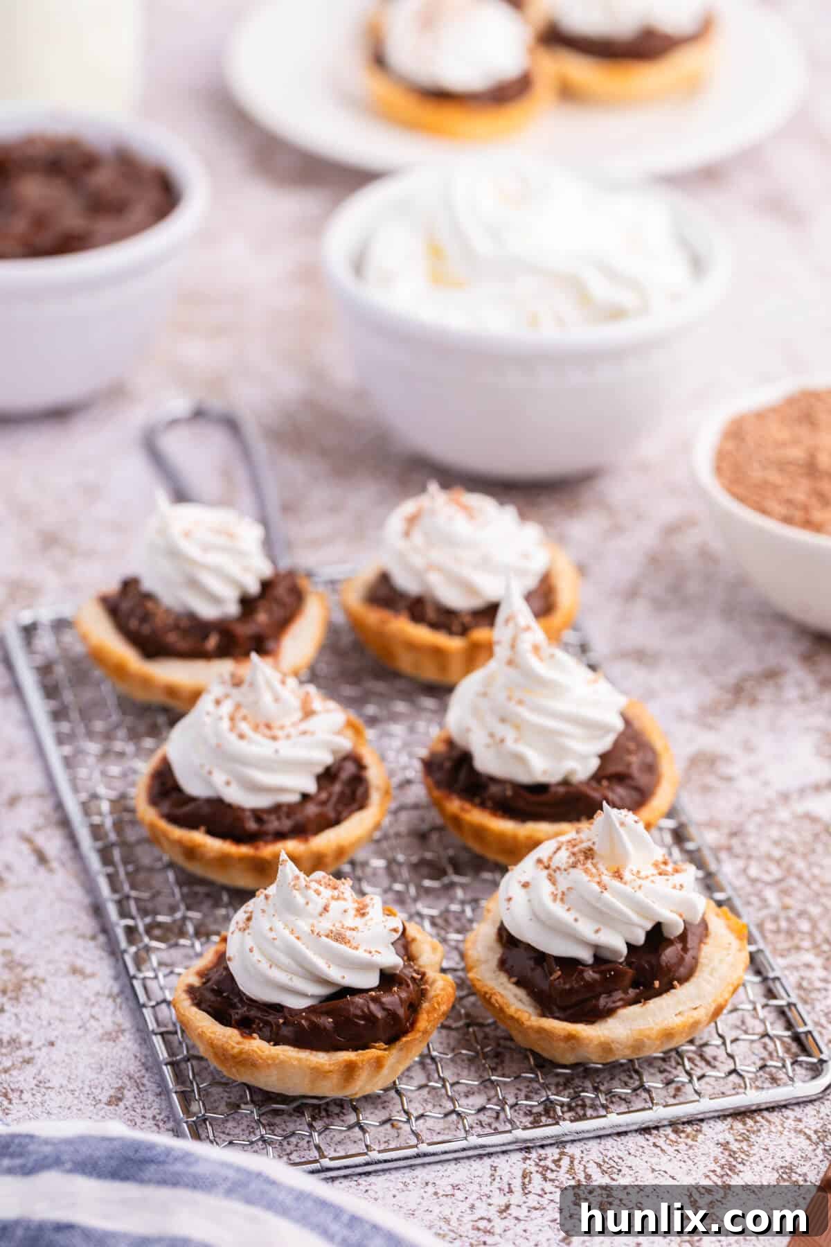 Irresistible Chocolate Cream Tarts artfully arranged on a wire rack.