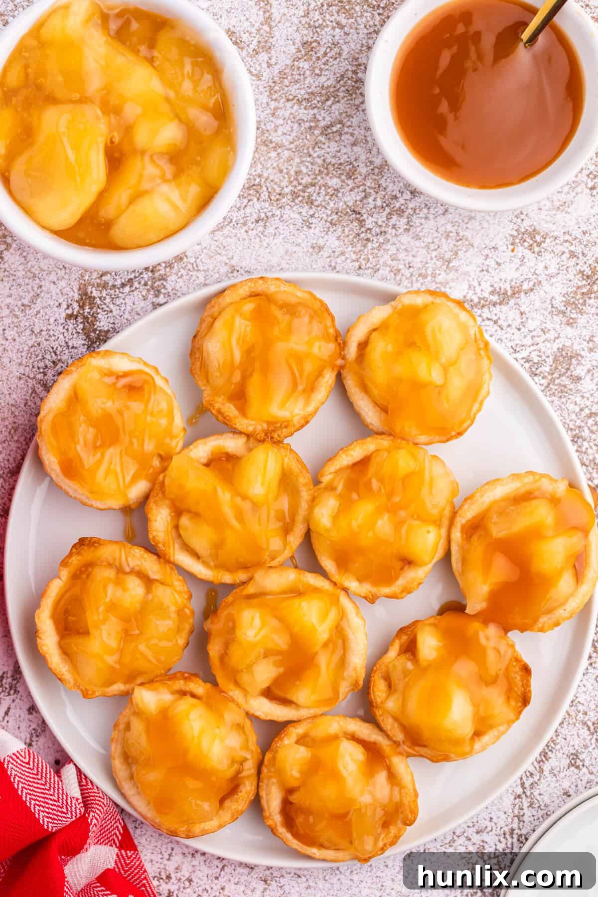 Caramel apple tarts on a plate, showcasing their golden crust and sweet topping.