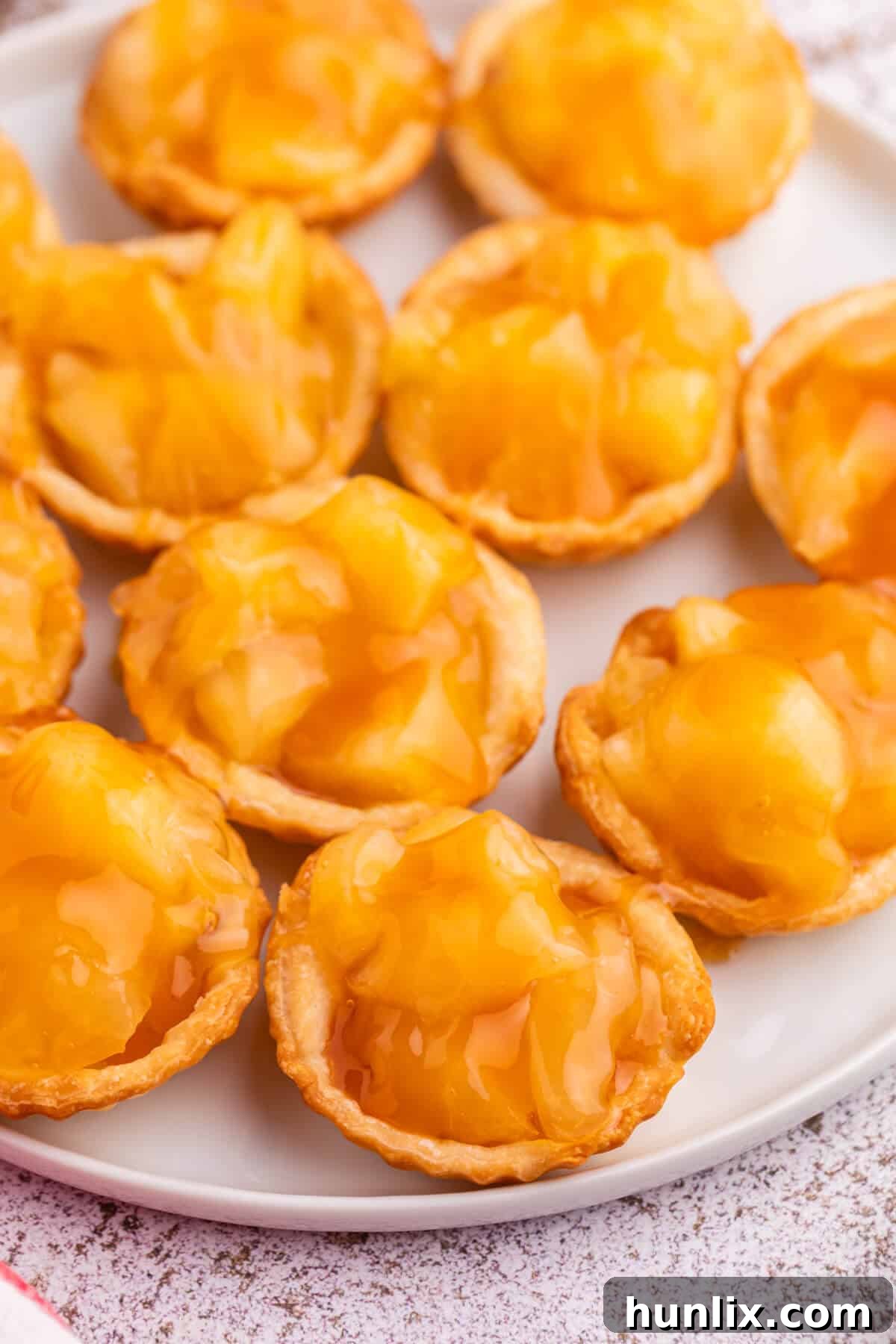 A tray of freshly baked and filled caramel apple tarts.