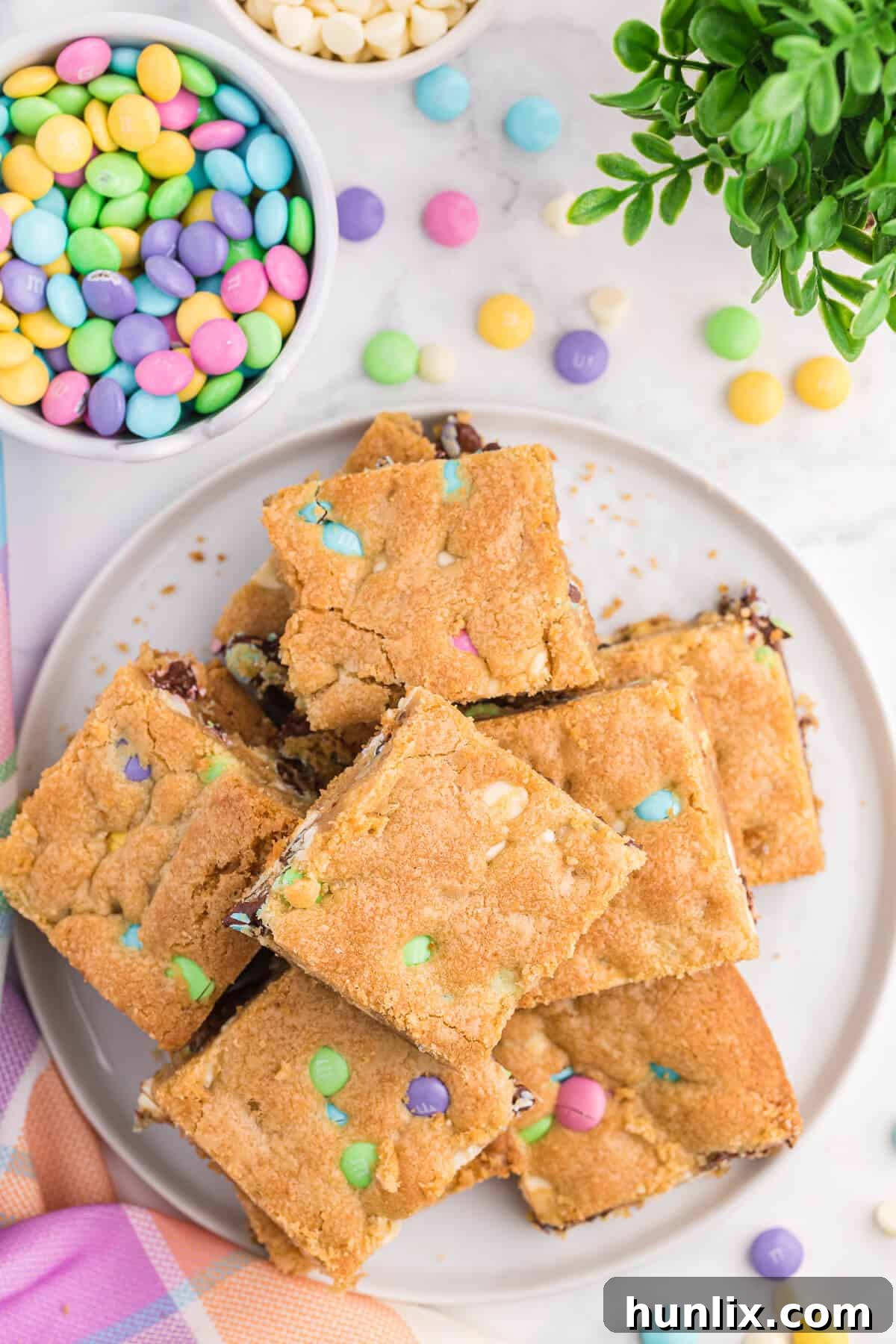 Spring Bloom Cookie Bars 3 A white plate artfully arranged with several cut Spring Cookie Bars, highlighting their thick, chewy texture and colorful M&M inclusions.