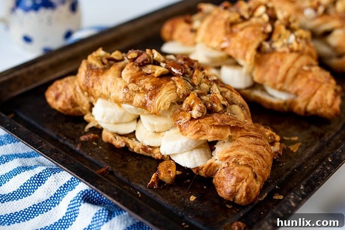 Sticky banana croissants on a baking sheet, ready to be served.