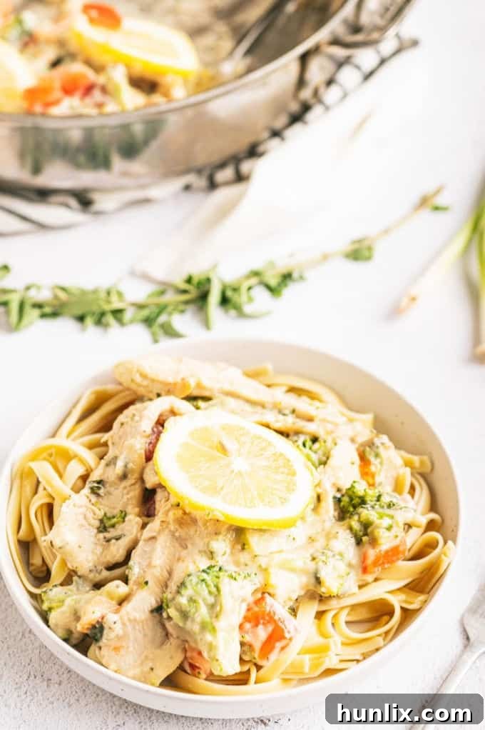 Zesty Lemon Herb Chicken Fettuccine 8 A bowl of Lemon & Herb Chicken Fettuccine garnished with fresh tomatoes and herbs
