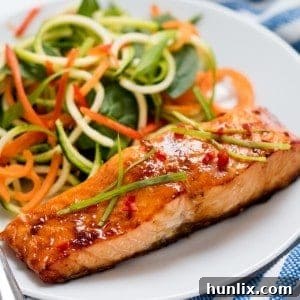Delicious Honey Garlic Baked Salmon served on a plate with fresh salad.
