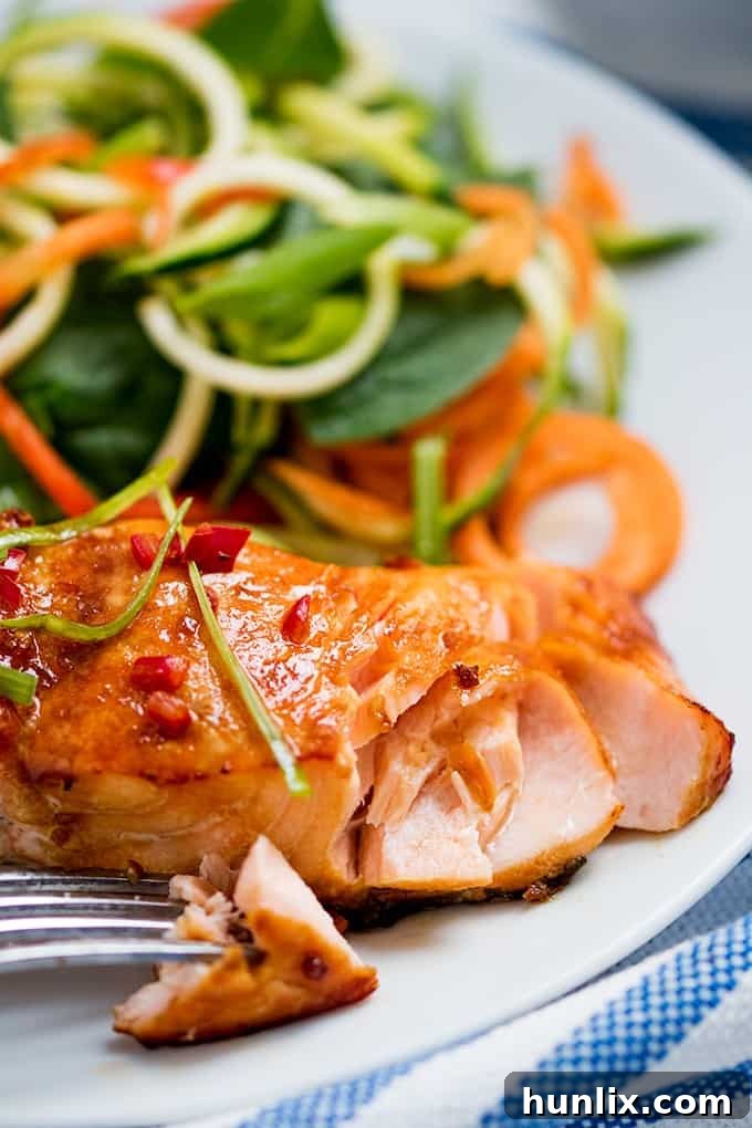 Honey garlic salmon plated with a vibrant couscous salad and fresh greens for a complete and healthy meal.