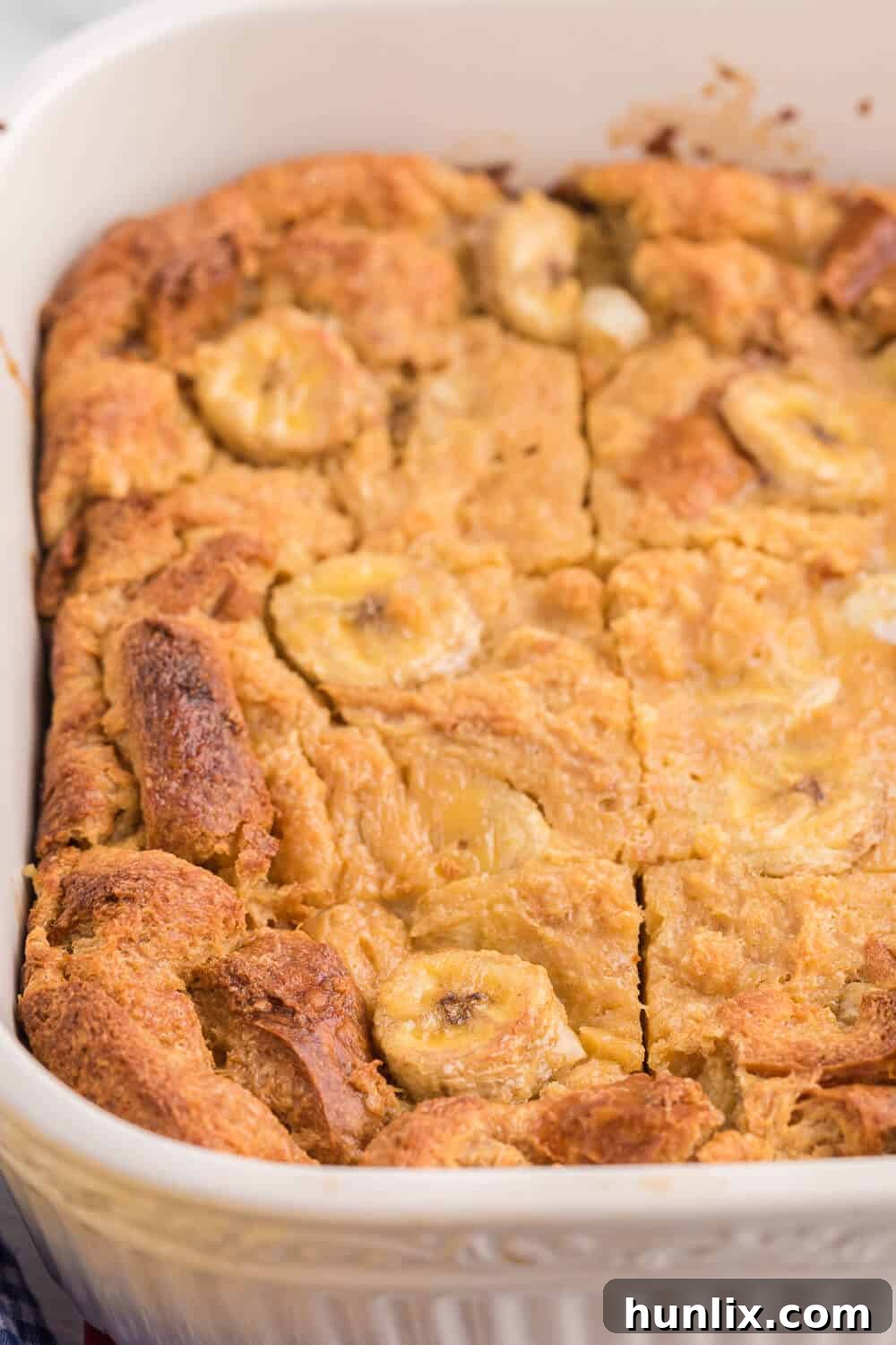 The Banana Bread Breakfast Casserole baking in a ceramic pan, showing its golden crust.