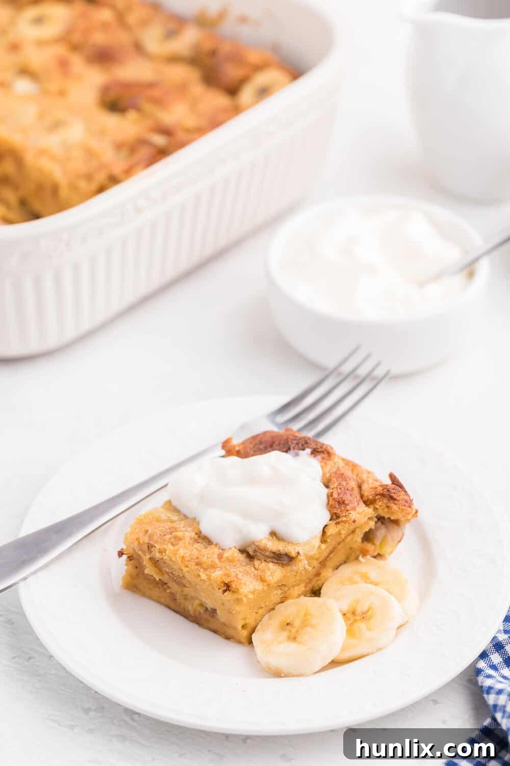 A perfectly sliced piece of Banana Bread Breakfast Casserole on a white plate, ready to be enjoyed.