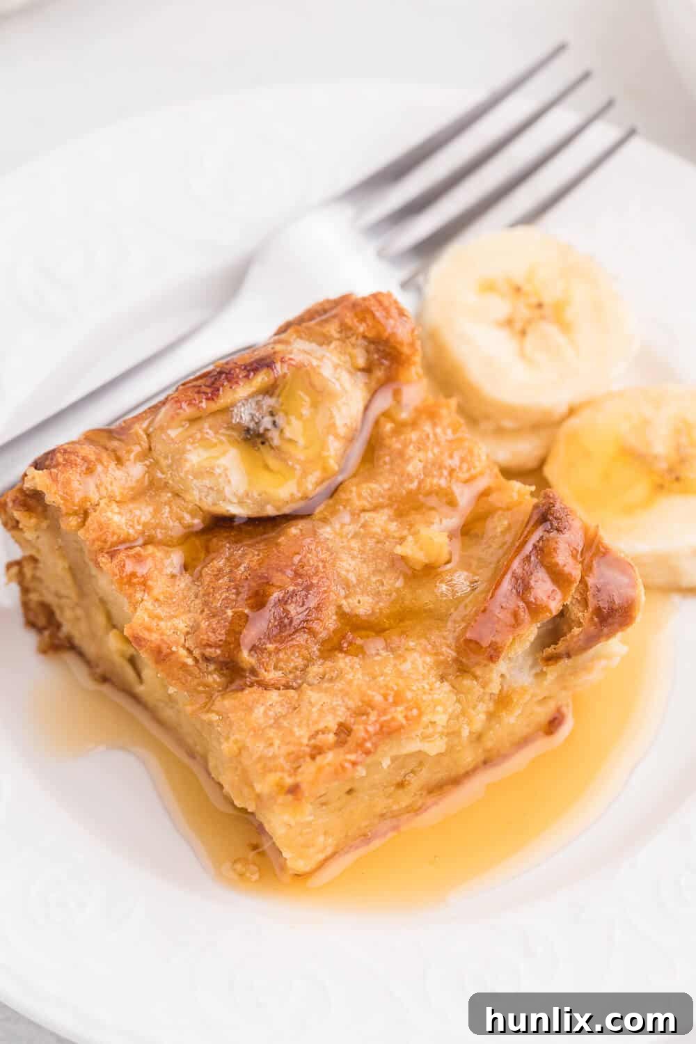 A final close-up of a slice of Banana Bread Breakfast Casserole on a plate, garnished and ready.