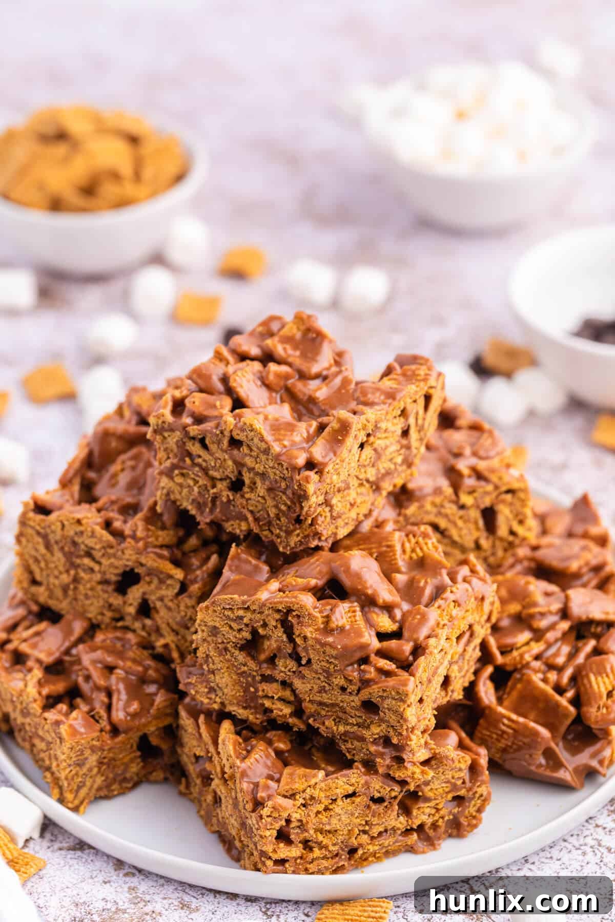 A plate featuring several perfectly cut pieces of indoor s'mores, showcasing their attractive layers.