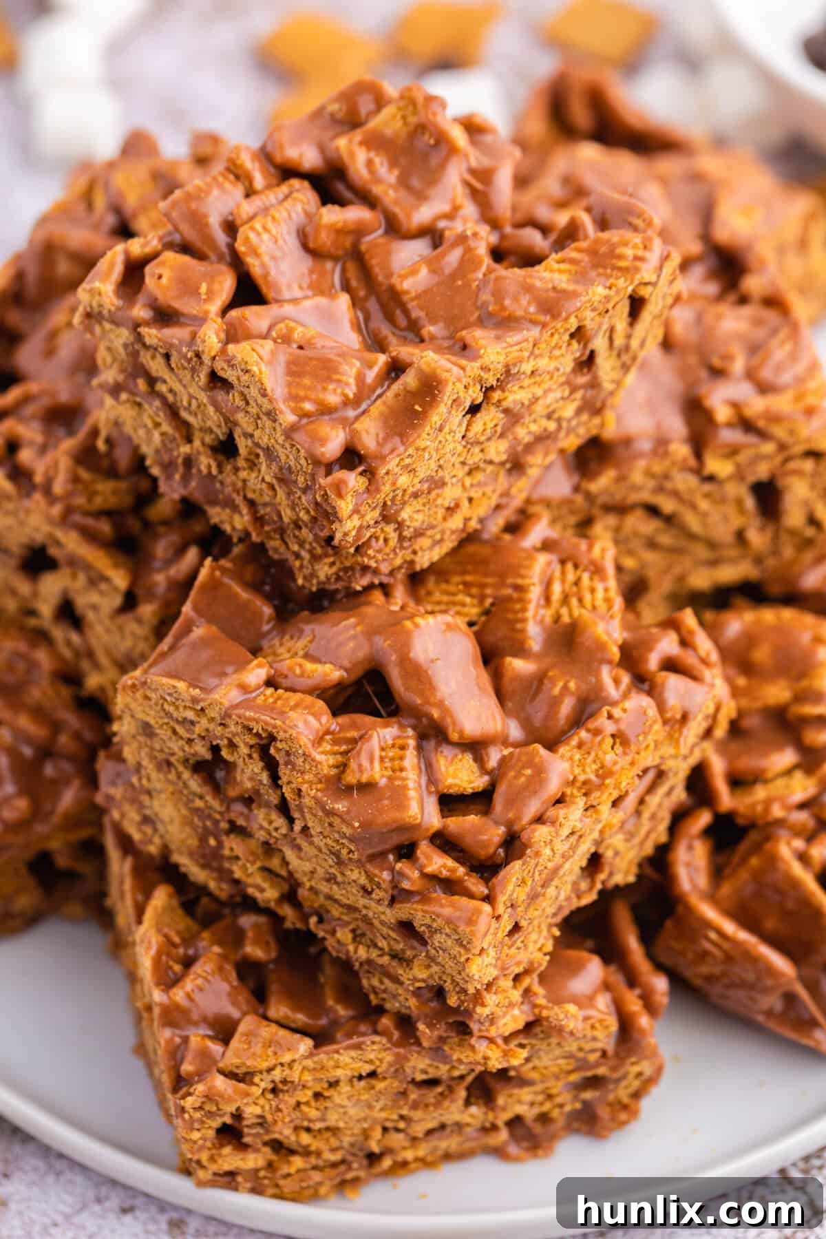 A stack of three indoor s'mores bars on a small plate, ready to be enjoyed.