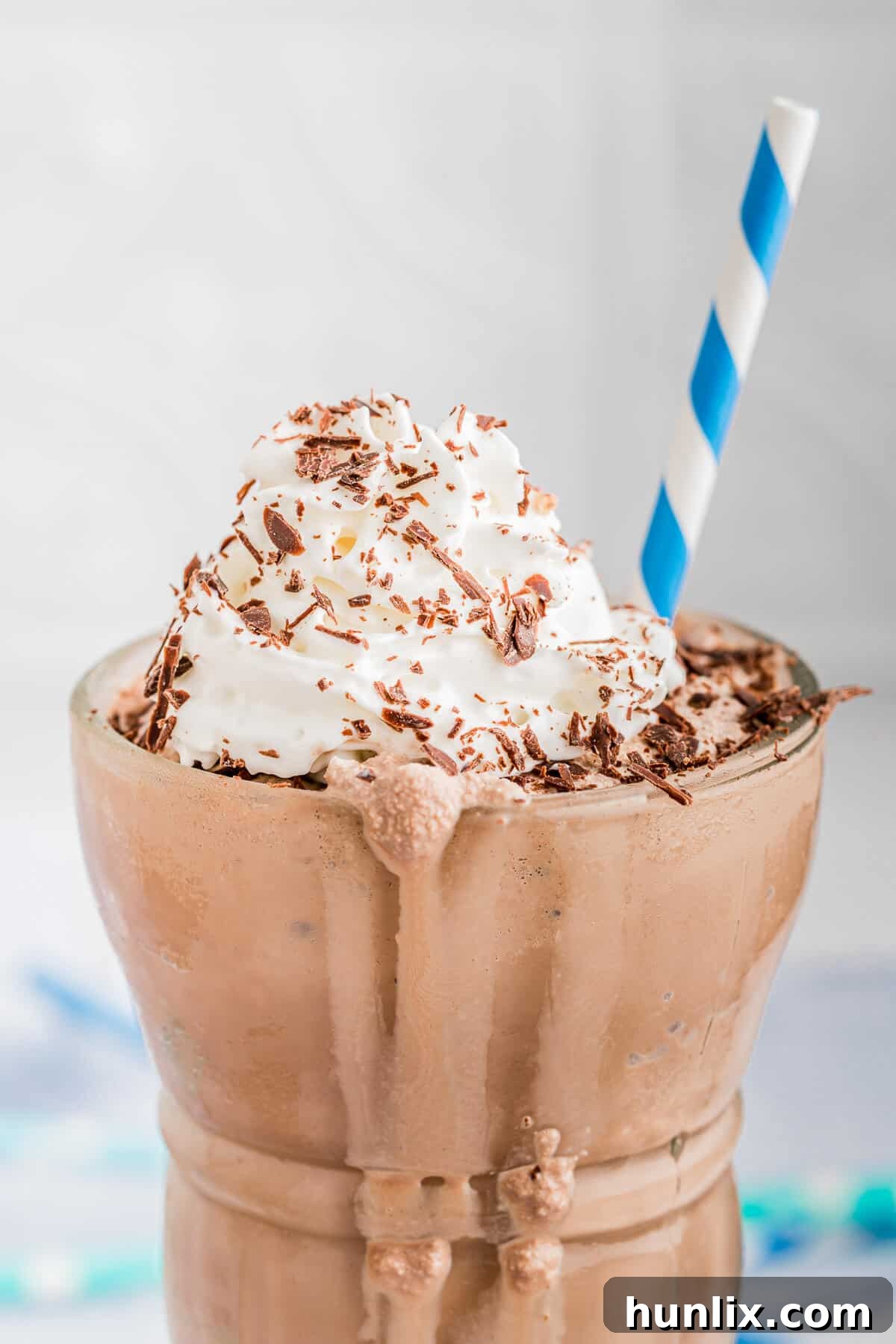 A close-up shot of a creamy Nutella coffee milkshake in a clear glass, showing its rich texture and toppings.