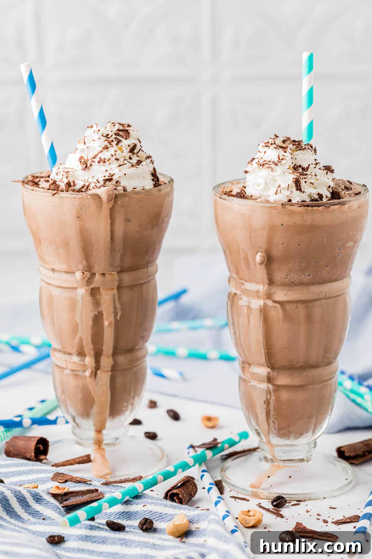 Two enticing glasses of Nutella coffee milkshake, garnished with whipped cream and chocolate shavings.