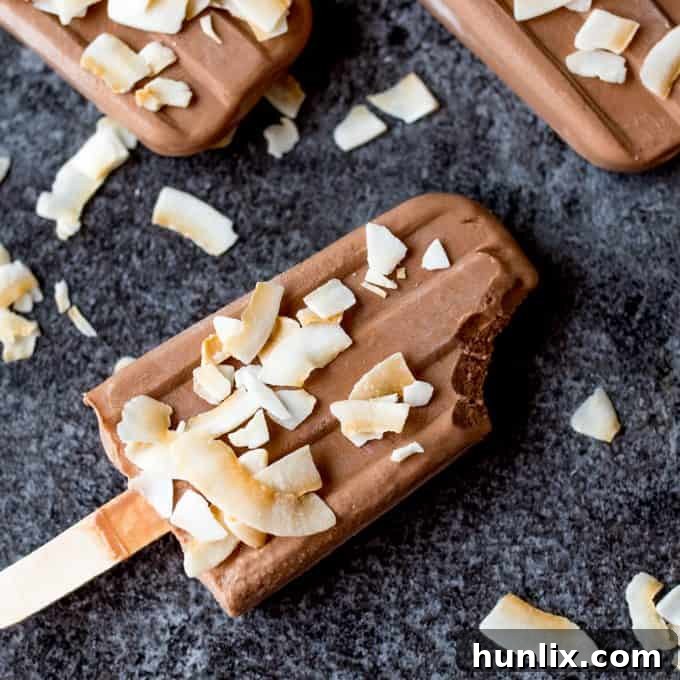 Toasted coconut fudgsicle with a bite out of it.