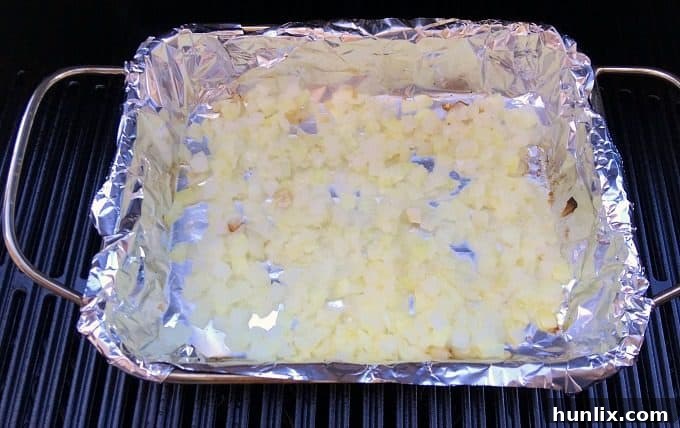 Preparing ingredients for Deluxe Pizza Burgers, including freshly diced onions ready for grilling.