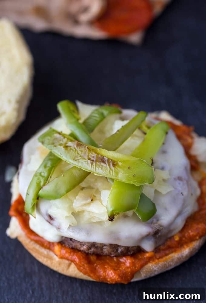 Grilled green peppers artfully placed on a Deluxe Pizza Burger with melted mozzarella and onions.