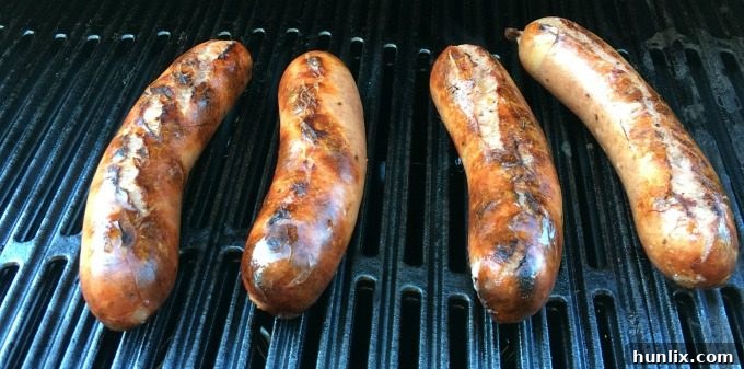 Mild Italian sausages grilling to perfection, sliced and ready for the pizza burgers.