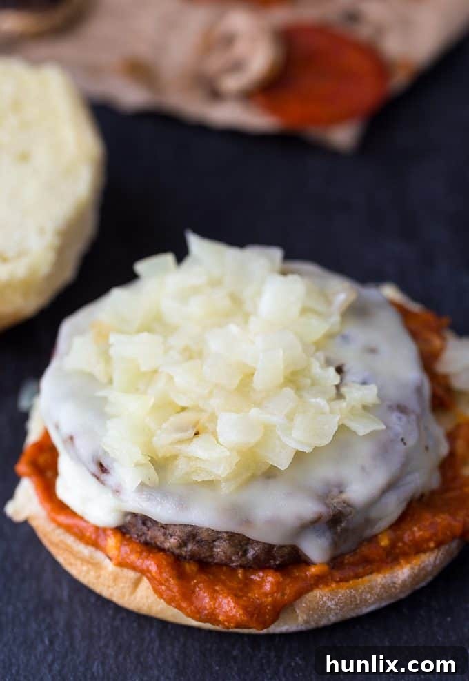 Grilled onions piled on top of a cheese-covered Angus burger patty.