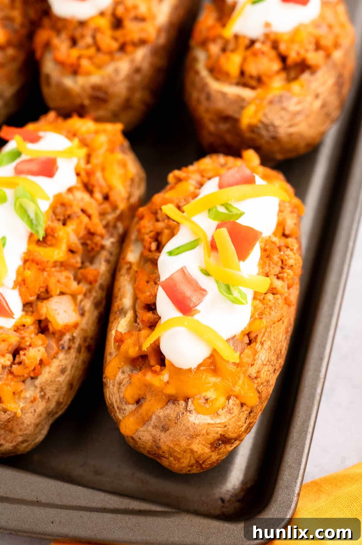 Chicken taco twice-baked potatoes on a baking sheet, ready to be served.