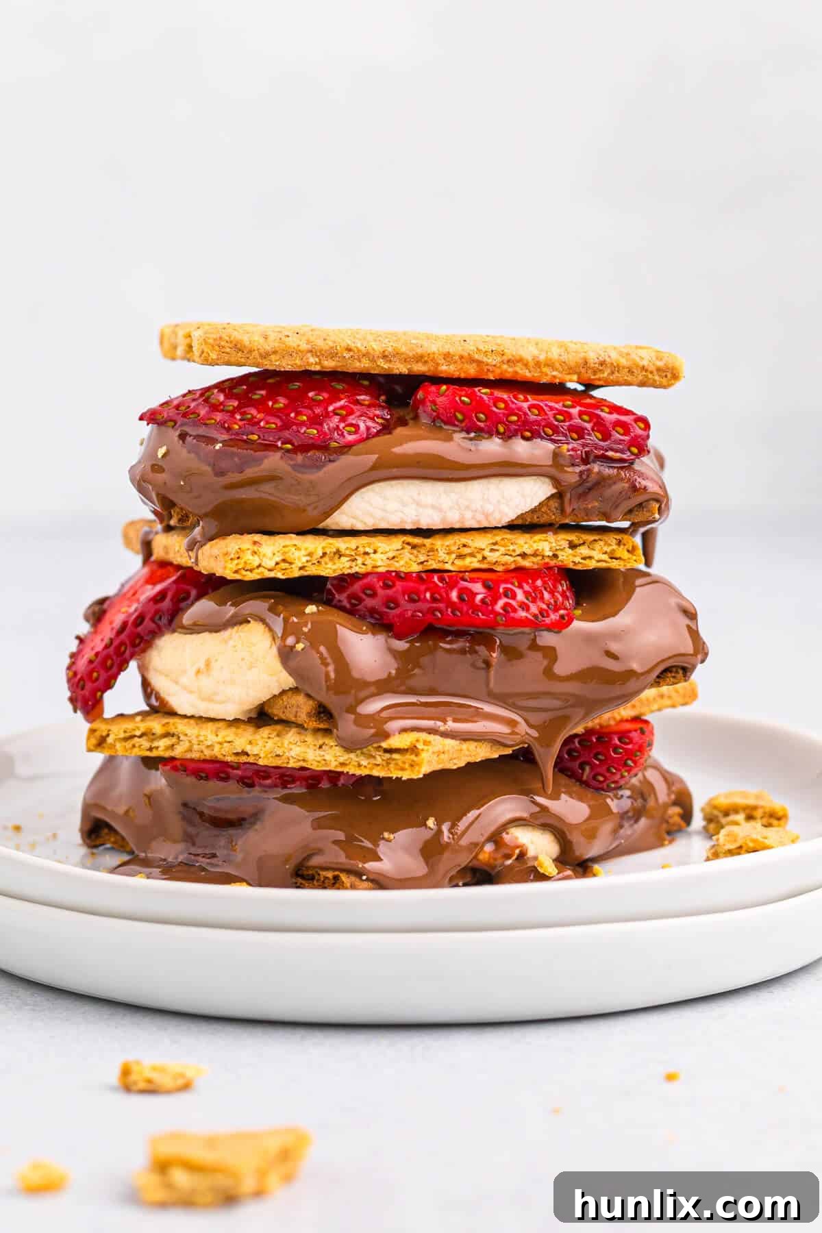 A stack of strawberry s'mores on a plate, highlighting the delicious layers.