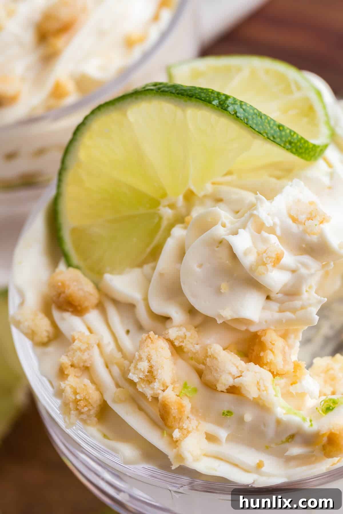 A close-up shot of a single lime cheesecake parfait, focusing on the texture and layers.