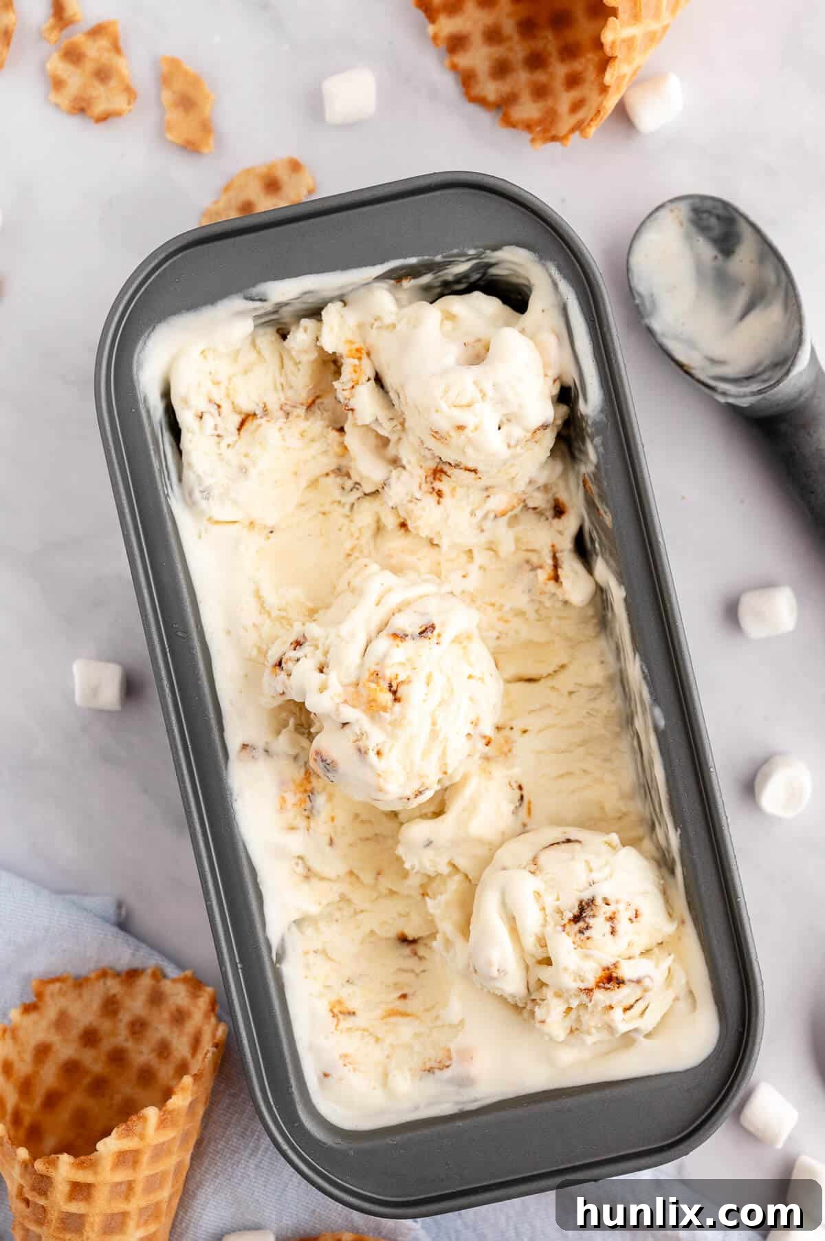 A loaf pan filled with golden brown toasted marshmallow ice cream.