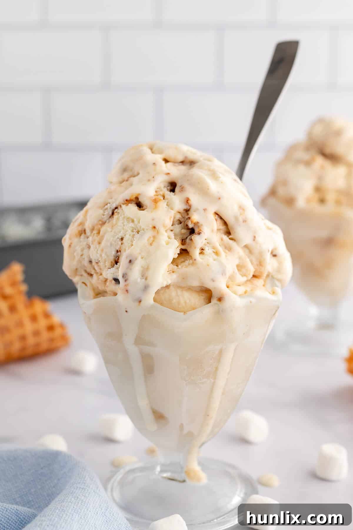 Toasted Marshmallow Ice Cream served in a clear glass dish with a spoon.