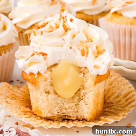 A cupcake cut in half, showcasing its layers of crust, cake, and creamy filling.